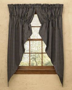 a window with a checkered curtain hanging on it's side and a tree in the background