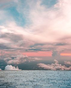 the sky is filled with white clouds and blue bricks