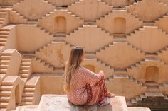 a woman sitting on top of a stone structure