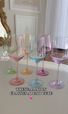 there are many different colored wine glasses on the table