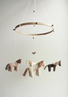 three toy horses hanging from a circular mobile