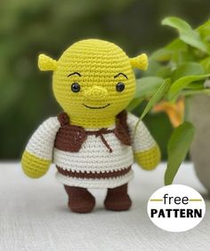 a small crocheted toy is standing next to a potted plant with the text free pattern