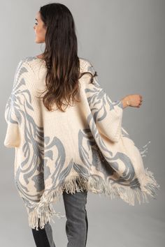 A chic and comfy layering piece, the Elora Knit Tassel Kimono displays floral and leaflet motifs, fringed edges, and is made from soft fabric that will keep you cozy this fall and winter. It is designed to rest comfortably on your shoulders and can be styled with the front open or fastened closed with a belt or pin for a more structured look. Material: Acrylic Size: 25" x 40" + 5.5" Fringe Winter Beige Fringe Shawl, Beige Fringed Winter Shawl, Beige Fringed Shawl For Winter, Cream Bohemian Shawl For Fall, White Fringe Shawl For Winter, White Fringed Winter Shawl, Beige Fringe Poncho For Fall, White Fringed Shawl For Winter, Kimono With Fringe