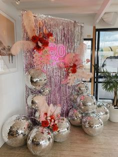 disco balls and streamers are on display in front of a wall decorated with flowers