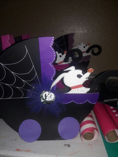 there is a black and purple paper plate with halloween decorations on it, along with other items