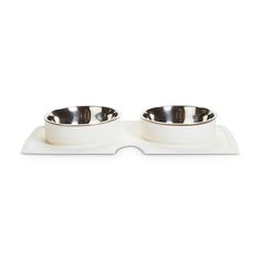 two white bowls with silver rims on top of each other in front of a white background