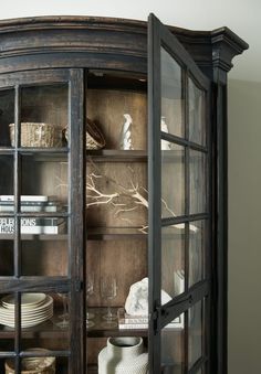 an old fashioned china cabinet with glass doors