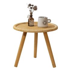 a wooden table with a coffee cup on it and a pine cone shaped plant in the middle