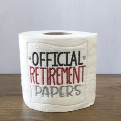 a roll of toilet paper with the words official retirement papers printed on it, sitting on a wooden surface