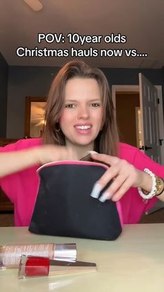 a woman sitting at a table with her purse and makeup products on the table in front of her