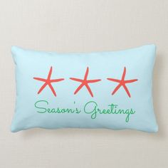 three red starfishs sitting on top of a light blue pillow that says season's greeting