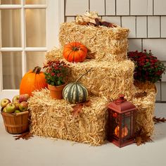 a stack of hay with pumpkins and gourds