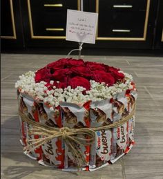 a cake decorated with roses and candy bars is on the floor in front of a door