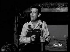 a black and white photo of a man holding an old camera in front of him