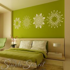 a bedroom with green walls and white flowers on the wall