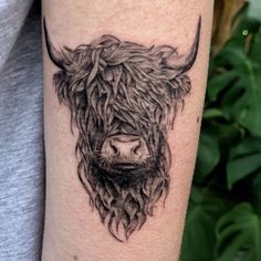 a black and white photo of a bull's head on the left calf arm