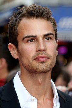 a close up of a person wearing a suit and white shirt with a black blazer