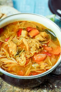 a bowl of chicken noodle soup on a table