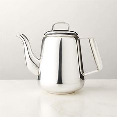 a stainless steel tea pot on a white table