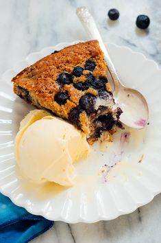 a piece of blueberry pie on a plate with ice cream