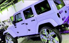 a white jeep is parked in a showroom