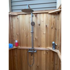 the shower head is attached to the side of the wooden wall in this outdoor shower