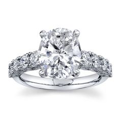 an oval cut diamond engagement ring with two side stones on the shoulders and sidestones