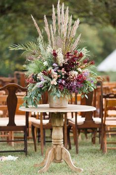 a table with flowers on it in front of an outdoor ceremony area at a wedding