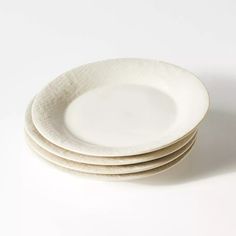 four white plates stacked on top of each other in front of a white background,