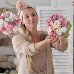 a woman holding flowers in her hands while standing next to another woman with long blonde hair