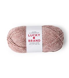 a ball of yarn with the label lucky brand on it, in pink and white