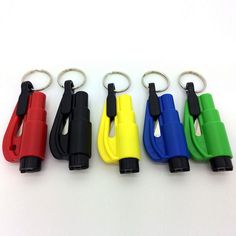 four different colored plastic whistles are shown in this image, with one keychain attached