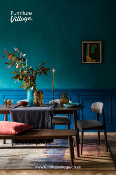 a dining room with blue walls and furniture