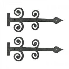 two wrought iron brackets with decorative designs on the top, and one is holding an arrow