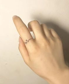 a woman's hand with a tiny ring on her left thumb and the word love written in it