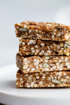 three pieces of granola bars stacked on top of each other in front of a white plate