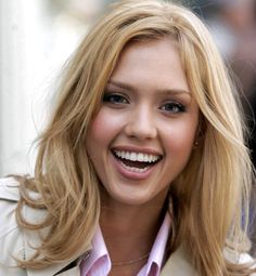 a woman with blonde hair smiling at the camera