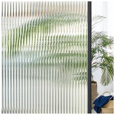 an image of the outside of a window with blinds on it and a potted plant next to it