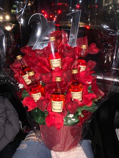 a bouquet of red roses and bottles of booze are on display in the back seat of a car