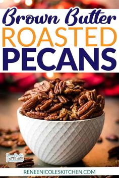 a white bowl filled with roasted pecans on top of a wooden table