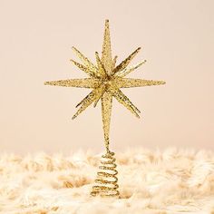 a gold christmas tree topper with a star on it