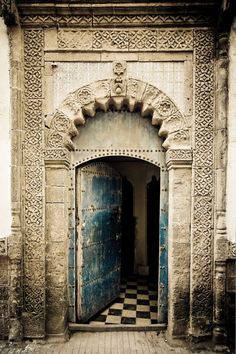 an old building with a blue door and checkered floor