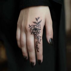 a woman's hand with a flower tattoo on it