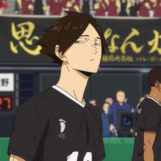 two men standing next to each other in front of a crowd at a soccer game