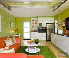 a living room with orange couches and green wallpaper on the walls in it