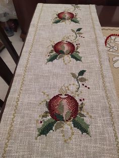 a cross stitch table runner with roses on it