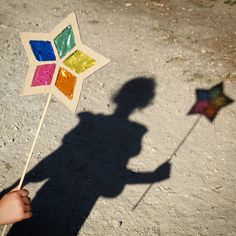 a shadow of a person holding a colorful pinwheel