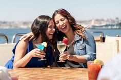 two women sitting at a table with drinks