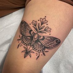 a black and white butterfly tattoo on the arm