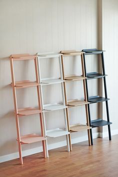 three shelves are lined up against the wall, one is empty and the other has no bookshelves